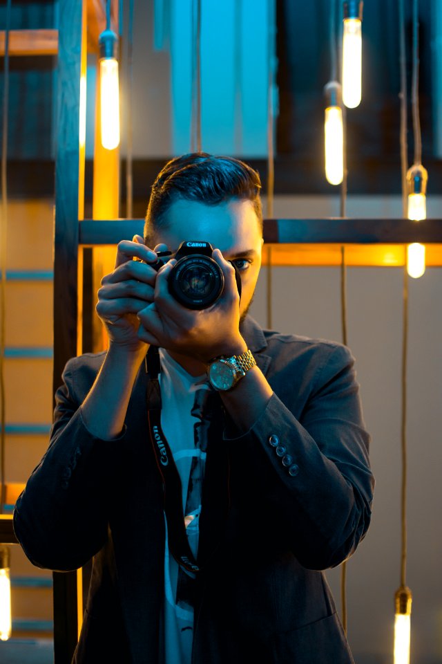 Man In Black Suit Holding Canon Dslr Camera
