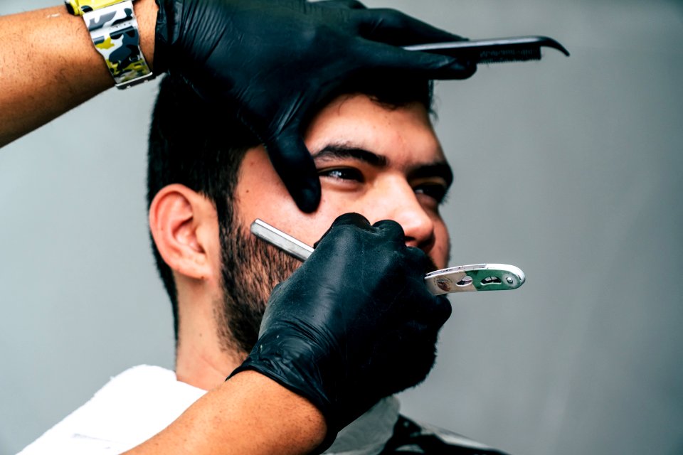 Person Shaving A Mans Face With Straight Razor