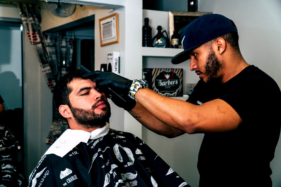 Man Wearing Black Shirt Trimming The Hair Of Man photo