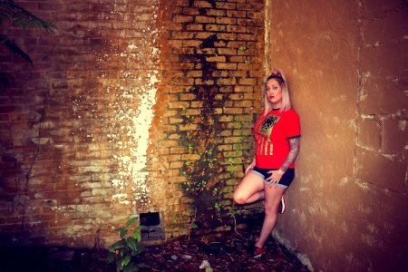 Woman Wearing Red Crew-neck Sleeved Shirt And Blue Denim Short Shorts photo