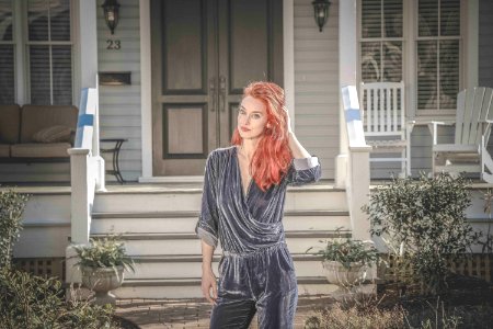 Woman Wearing Gray Peplum Elbow-sleeved Jumpsuit Standing In Front Of House photo