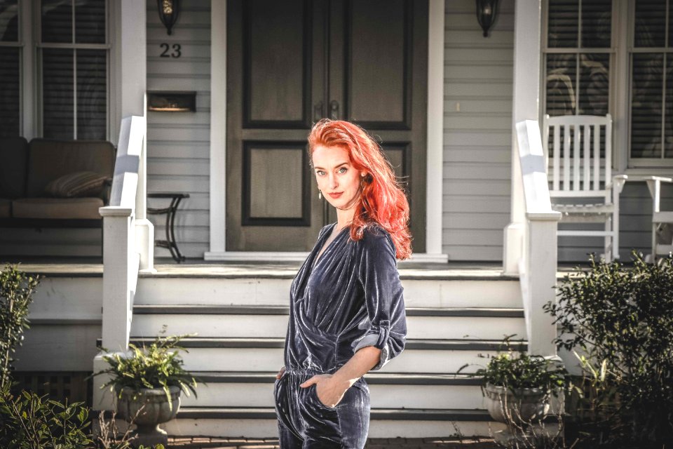 Woman In Gray Jumpsuit Standing In Front Of House