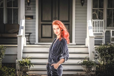 Woman In Gray Jumpsuit Standing In Front Of House photo