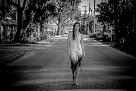 Greyscale Photo Of Woman Standing On Street photo