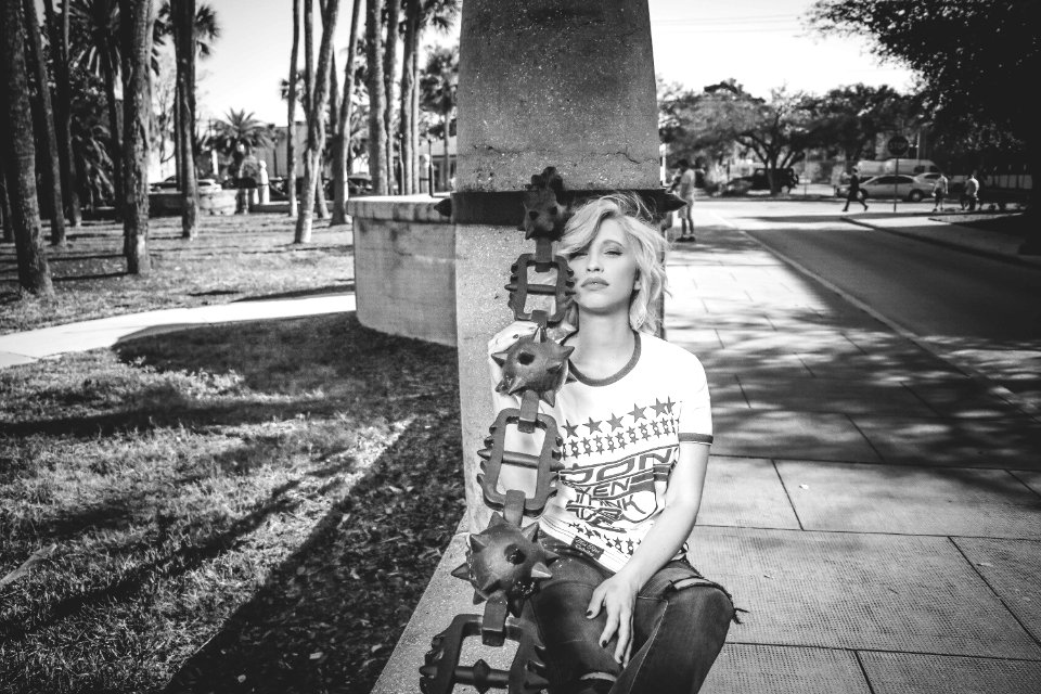 Grayscale Photo Of Woman Leaning On Concrete Post photo