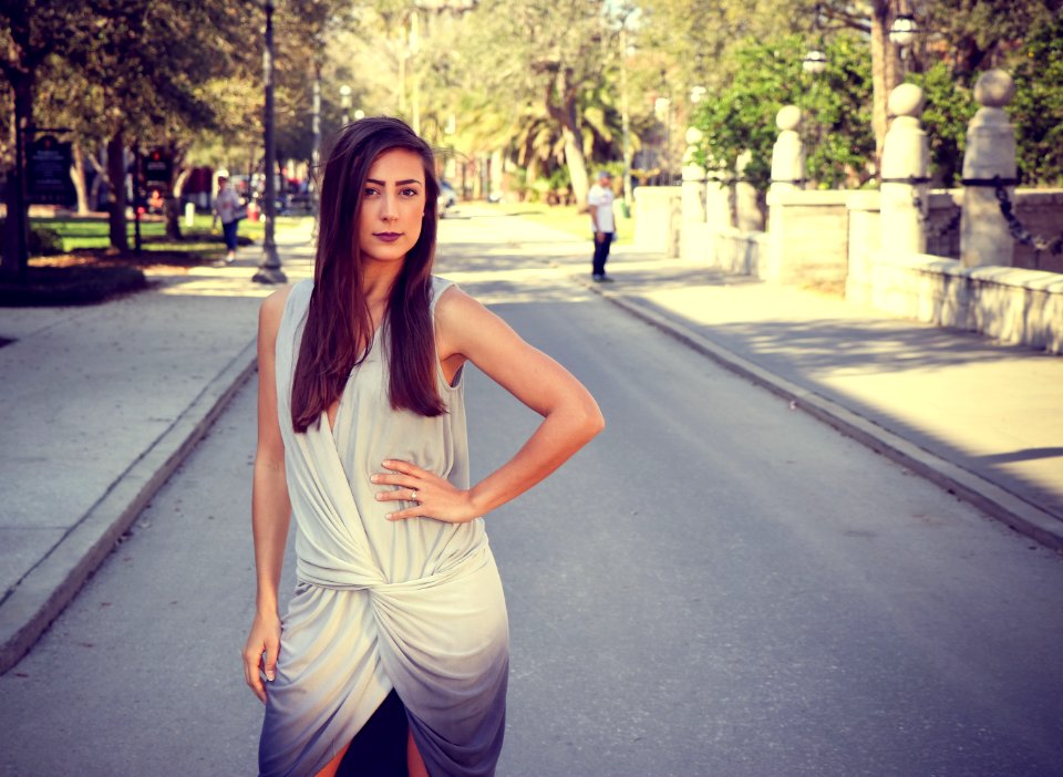 Woman Weairng White And Gray Sleeveless Dress Standing On Gray Road