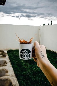 Person Holding Starbucks Cup With Brown Beverage