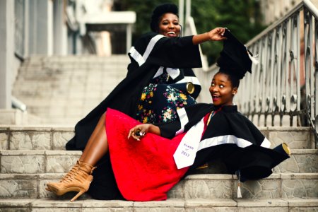 Shallow Focus Photography Of Two Women In Academic Dress On Flight Of Stairs photo