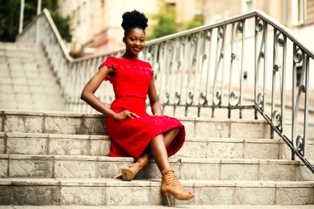 Woman In Red Off-shoulder Dress With Brown Leather High Heeled Gladiator Sandals On Brown Stairs photo