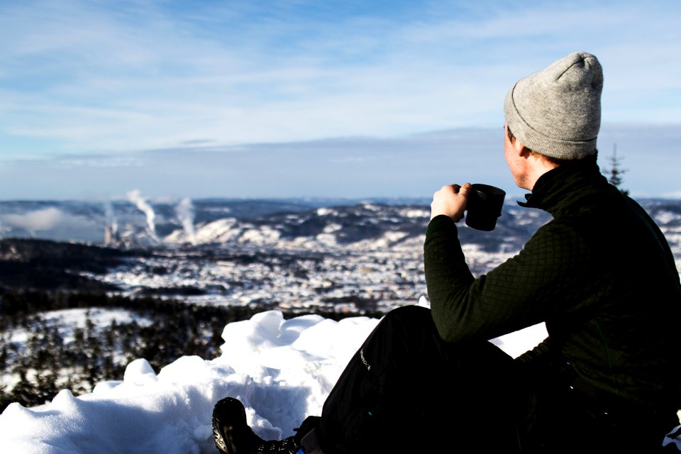 Man Wearing Jacket And Holding Cup Sitting On The Snow