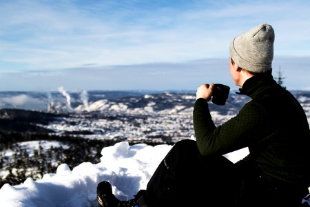 Man Wearing Jacket And Holding Cup Sitting On The Snow