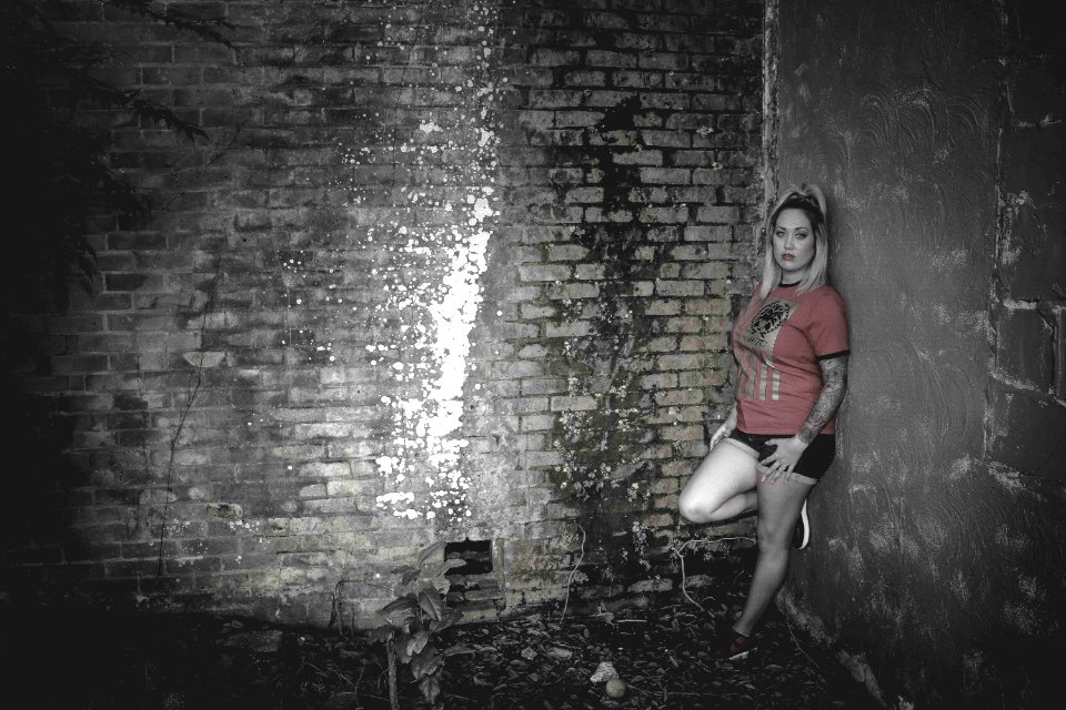 Woman Wearing Orange Crew-neck Short-sleeved Shirt Leaning On Concrete Wall