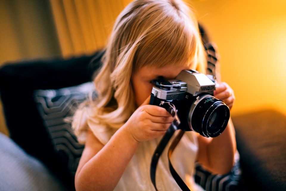 Shallow Focus Photography Of Girl Holding A Black And Silver Dslr Camera