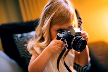 Shallow Focus Photography Of Girl Holding A Black And Silver Dslr Camera photo