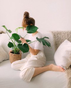 Woman Wearing White Crew-neck Shirt And White Pants While Sitting On White Couch photo