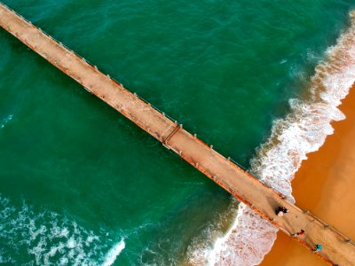 Aerial Photography Of Brown Boardwalk Near Green Water On Beach photo