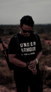 Man Wearing Black And White Under Armour Shirt And Holding His Watch photo