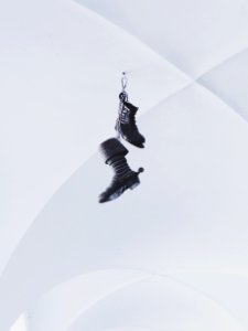 Pair Of Black Boots Hanging On White Wall photo