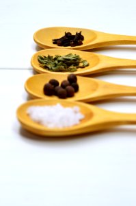 Four Assorted Spices On Brown Wooden Spoon photo