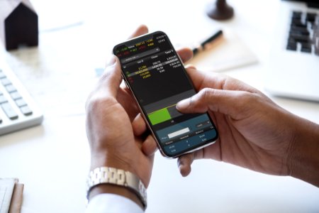 Person Holding Smartphone In Front Of Desk photo