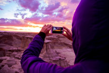 Person Wearing Purple Hoodie Jacket Holding Iphone 6 During Golden Hour photo