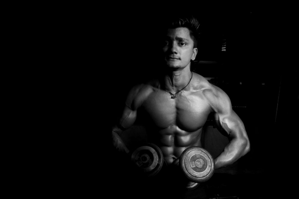 Grayscale Photo Of A Man Holding Pair Of Dumbbells