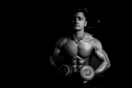 Grayscale Photo Of A Man Holding Pair Of Dumbbells photo