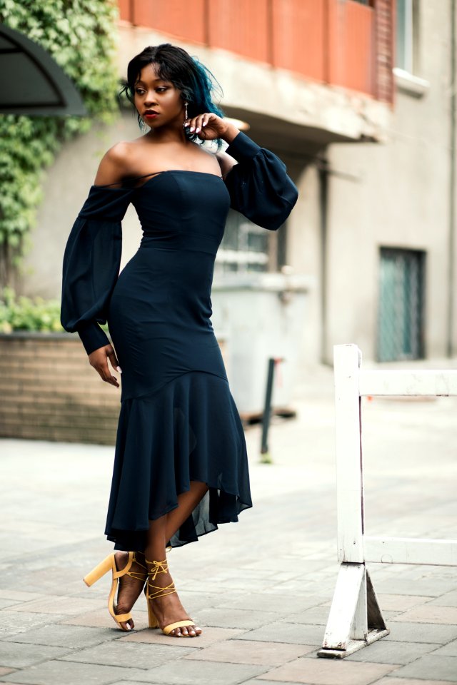 Woman Wearing Off-shoulder Standing Next To White Road Blockage