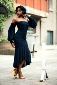 Woman Wearing Off-shoulder Standing Next To White Road Blockage