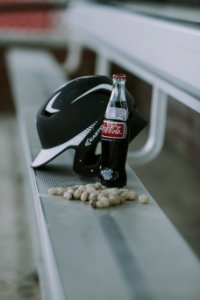 Coca-cola Bottle Beside Black Easton Batting Helmet photo
