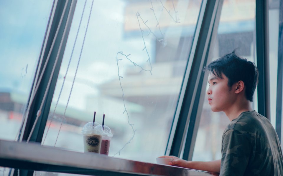 Man Sitting Beside Table Near Plastic Cups photo