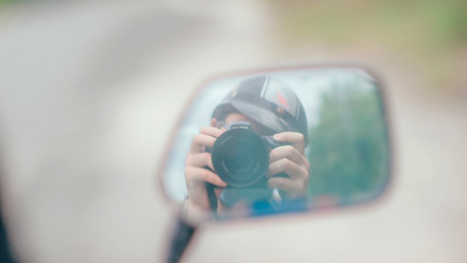 Shallow Focus Photography Of Person Holding Dslr Camera In Mirror Reflection photo