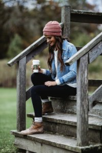 Woman Wearing A Blue Denim Jacket Holding A Cup Of Coffee photo