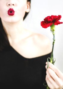 Photo Of A Woman Holding Red Carnation Flower photo