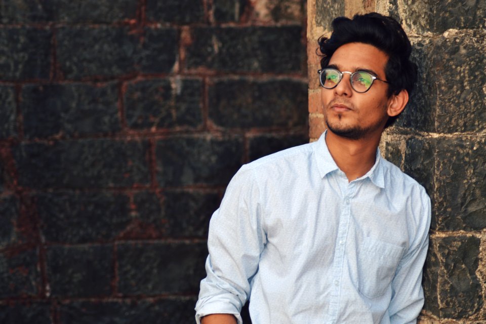 Man Leaning On Black Brick Wall