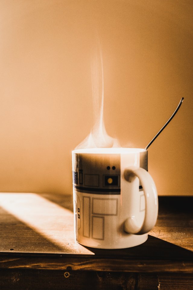 White And Grey Ceramic Mug On Brown Wooden Table photo