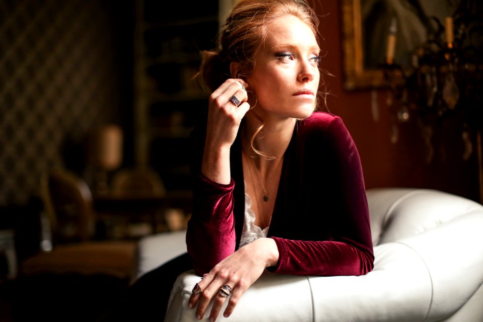 Selective Focus Photo Of A Woman Sitting On White Leather Sofa