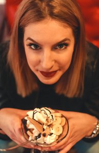 Woman Looking On Camera Holding Bowl With Ice Cream