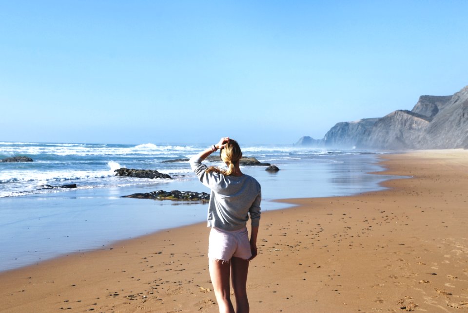 Woman In Gray Long-sleeved Shirt With Pink Short Shorts Standing Near Sea photo