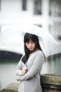Woman Wearing Gray Sweater Holding Clear Umbrella photo