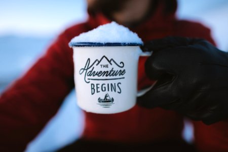 Selective Focus Photography Of Person Holding The Adventure Begins Mug photo