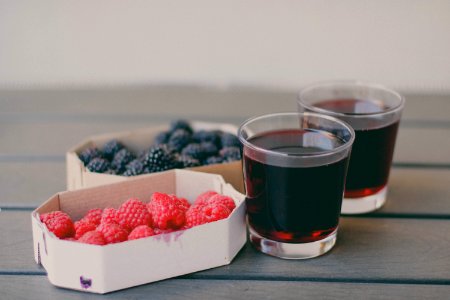 Two Drinking Glasses Filled With Raspberry And Blueberry Fruit Juices photo