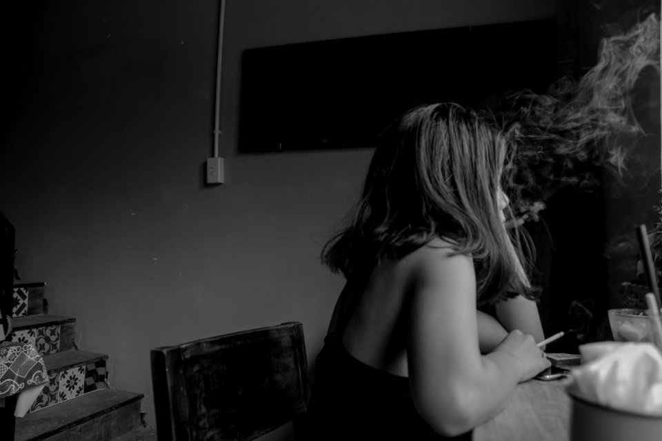 Grayscale Photo Of Woman Sitting On Chair Near Chair photo