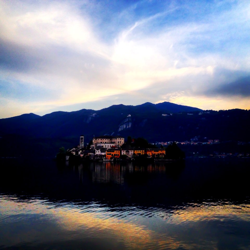 Buildings Near Body Of Water And Mountain