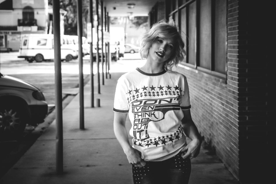 Woman In Crew-neck Shirt Standing Beside Brick Wall Building