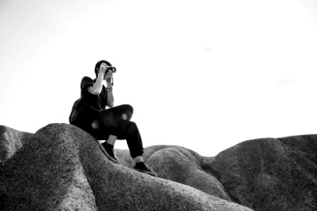 Person Sitting On Rocks Taking Photos photo