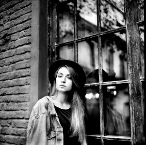 Grayscale Photo Of Womens Denim Jacket And Hat Leaning On Window photo