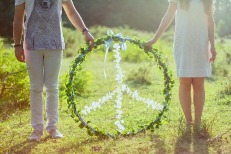 Two Person Holding White And Green Peace Wreath