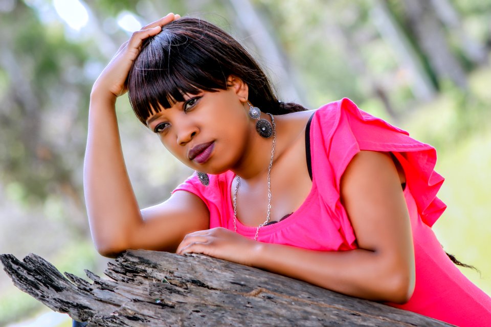 Selective Focus Photography Of Woman On Wood Holding Head photo