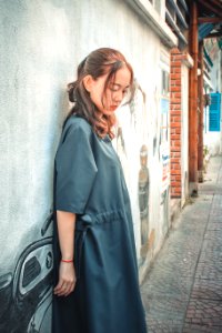 Woman Wearing Gray Coat Leaning On Gray Wall With Graffiti photo